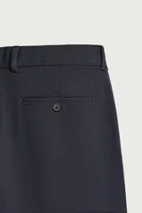 Pantalón chino negro slim fit de corte recto, con bolsillos frontales, trabillas para cinturón y cierre frontal con cremallera y botón.