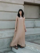 Vestido largo color beige, de seda, con breteles finos ajustables y volado en la espalda.