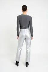 Pantalón de tiro medio confeccionado en eco cuero con acabado metalizado color plata, de corte recto y diseño clásico con bolsillos laterales y traseros.