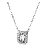 Collar con colgante Swarovski de la familia Millenia, con una circonita cuadrada transparente de talla escalonada enmarcada por piedras de talla brillante más pequeñas, engarzada en baño de rodio y cadena fina con cierre de mosquetón. Diseñado por la directora creativa Giovanna Engelbert.
