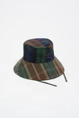 Gorro tipo bucket con estampado de cuadros en tonos verdes, azules y marrones, con logo de la marca bordado en el frente y cordones laterales.