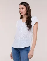 Blusa de gasa blanca con estampa de lunares negros, escote en V con botones frontales y mangas cortas casquillo con abertura.