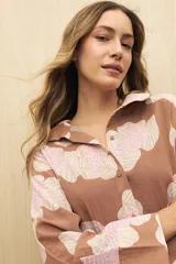 Vestido midi con estampado paisley en tonos azules y beige, con cuello camisero y abotonadura frontal.