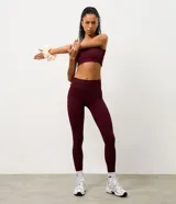 Legging deportiva de tiro alto confeccionada en microfibra acanalada color bordó, con diseño ajustado que se adapta al cuerpo.