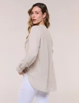 Blusa de lino de la marca Dash, color beige, con cuello mao y escote en V con botones frontales. Cuenta con bolsillos plaqué con solapa en el pecho y mangas largas con sistema para arremangar.