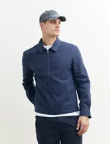 Campera de estilo harrington color azul oscuro, con cierre frontal, cuello camisero y bolsillo frontal tipo parche.