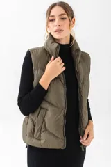 Chaleco puffer de cuello alto con cierre frontal, en color verde oliva.
