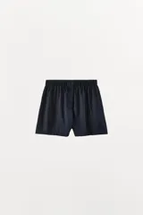 Short liso de tejido satinado color azul marino, de tiro medio con cintura elástica y botones frontales ocultos bajo sopata.
