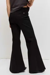 Pantalón negro de corte flare, tiro alto y diseño ajustado en la parte superior con piernas acampanadas.