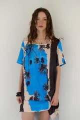 Vestido corto azul, beige y negro, con estampado floral, escote redondo y mangas cortas.