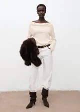 Jersey de punto de grosor medio, color crudo, con cuello drapeado y manga larga. Presenta un diseño recto y holgado.