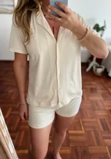Conjunto de pijama color crema con textura acanalada, compuesto por camisa de manga corta con botones y short.