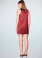 Vestido corto de tejido satinado en color bordó, sin mangas, con cuello redondo y diseño recto.