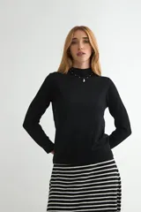 Polera de punto color negro, de corte ajustado, manga larga y cuello alto.