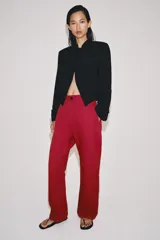 Blazer negro ZW Collection con cuello perkins, manga larga con vuelta en los puños y bajo asimétrico. Presenta detalles de alamares bordados en el frente.
