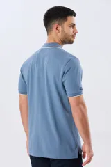Remera polo de piqué azul marino, con cuello y puños de mangas cortas con ribete blanco en contraste, cierre frontal de dos botones y pequeño logo bordado en el pecho.