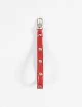 Llavero rojo de cuero sintético con tachas metálicas plateadas y gancho mosquetón.