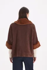 Saco de paño color marrón con cuello y puños de piel sintética al tono. Presenta un diseño de corte recto con cierre frontal de un solo botón.