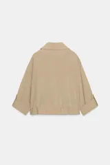 Chaqueta corta marrón de cuello solapa y manga remangada por debajo del codo. Presenta bolsillos delanteros de plastrón con solapa, bajo ajustable con cordón interior y cierre frontal con botones.