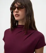Blusa Cortelle de viscosa color bordó, con cuello alto, manga corta y textura acanalada, de diseño ajustado al cuerpo y terminación sin costuras.