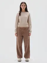 Jean estilo parachute de denim con estampado de rombos en tonos marrones. Presenta una silueta amplia, cintura ajustable con cordón y bajos con cordones para regular el ajuste.