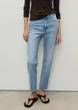 Jeans de tiro alto con diseño mom-fit, de cinco bolsillos y cierre frontal con cremallera y botón, en tejido de algodón estilo tejano vaquero de color celeste lavado.
