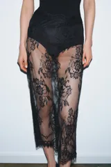 Body negro de corte cavado, con escote en V y tirantes finos ajustables. Presenta aplicación de encaje negro en el escote y en los laterales de la cadera.