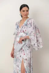 Vestido largo de gasa con estampado floral, escote en V, drapeado en el corsé, mangas amplias estilo capa y tajo frontal en la falda.