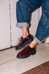 Zapatos tipo wallabee de cuero metalizado en tono peltre, con cordones negros y suela track de goma negra con plataforma.