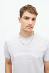 Remera clásica de manga corta color lila, con estampado frontal del logo "BROOKSFIELD CLUB" en blanco.