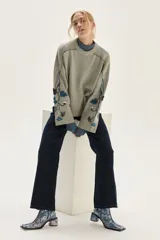 Sweater de punto color gris con cuello redondo, mangas amplias y diseño floral bordado a mano en las mangas.