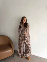 Conjunto de dos piezas compuesto por camisa de manga larga con botones y pantalón de corte recto y holgado, ambos confeccionados en tela de viyela con estampado de cuadros en tonos blanco y negro.
