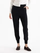 Pantalon sastrero negro con diseño tipo jogger, cuenta con bolsillos delanteros, bolsillos ojal traseros, cinta lateral de cuero y puños tejidos en ribb en el ruedo.