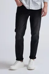 Pantalón de jean slim fit color gris oscuro, con desgaste en la parte superior de los muslos y ruedo con dobladillo.