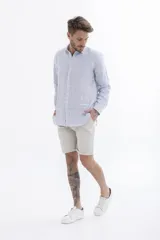 Camisa celeste a rayas verticales blancas, de manga larga y corte clásico.