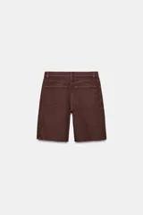 Bermuda de denim color bordó, de tiro medio y corte relaxed, con diseño de cinco bolsillos, trabillas para cinto y bajo desflecado.