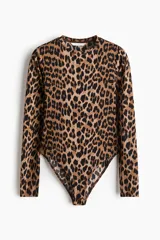Body de manga larga con escote redondo, confeccionado en punto elástico con estampado de leopardo. Cuenta con refuerzo interior con botones a presión y frente forrado.
