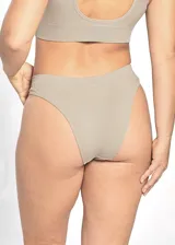 Bombacha de bikini color beige claro, confeccionada en tejido acanalado (rib) elástico, con tiro medio/bajo y corte clásico.