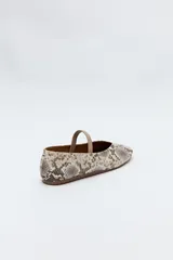 Balerina negra de cuero sintético con punta redondeada, escote en V y tira elástica sobre el empeine.