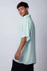 Camisa de manga corta con cuello cubano, confeccionada en fibrana premium. Presenta un corte oversize y cierre frontal con botones al tono.