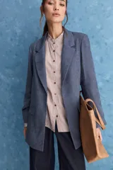 Blazer de corte recto y silueta relajada, de color tostado, con solapas clásicas y bolsillos con solapa en los laterales.