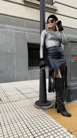 Falda midi negra de gabardina metalizada elastizada, con tachas en la cintura y flecos en el ruedo.