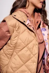 Chaleco acolchado color camel con diseño de rombos. Interior con estampado floral.