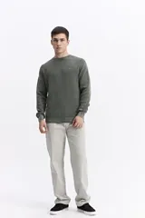 Sweater de hombre con textura waffle, color verde oliva desgastado (acid wash), cuello redondo y puños y ruedo acanalados. Presenta un pequeño logo bordado en el pecho.