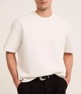 Remera de corte boxy con cuello redondo y mangas cortas, confeccionada en tejido de malla pesada con textura gomosa.