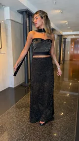 Top strapless tejido con hilo lurex negro y dorado, con escote corazón y detalles de apliques de crochet negros en el borde superior.