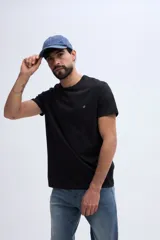 Remera básica de algodón pima color negro, de manga corta y cuello redondo, con pequeño detalle bordado en el pecho.