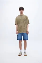 Remera celeste con efecto marmolado, bolsillo en el pecho con parche decorativo y arte en la espalda baja. De calce oversize y algodón lavado con textura extra suave.