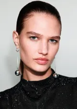 Top sin mangas de cuello perkins, confeccionado en tejido negro con acabado brillante de strass. Presenta un diseño entallado y cierre de botón en la parte posterior del cuello.