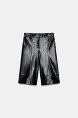 Bermuda negra de tiro alto con efecto piel, bolsillos delanteros y falsos bolsillos de vivo en la espalda. Cierre frontal con cremallera, botón interior y gancho.